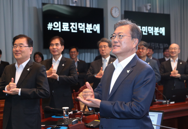 문재인 대통령이 27일 오후 청와대에서 수석·보좌관 회의를 주재하기에 앞서 참석자들과 함께 신종 코로나바이러스 감염증(코로나19) 의료진에게 감사한 마음을 전하는 ‘덕분에 챌린지’에 참여하고 있다. 문 대통령은 이날 SNS 메시지를 통해 “의료진 덕분에, 서서히 일상을 준비하게 됐다”며 “우리의 응원이 의료진 여러분에게 자부심이 되었으면 좋겠다”고 전했다./연합뉴스