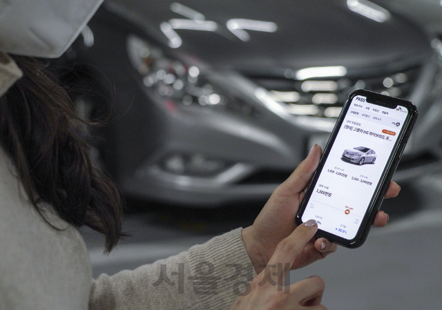 SK텔레콤 모델이 본인인증 앱 ‘패스’를 통해 중고차 시세 조회 등을 할 수 있는 ‘패스 자동차’를 사용하고 있다./사진제공=SK텔레콤