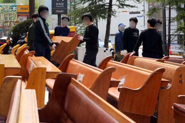 지난 20일 오전 경기도 과천시 별양동의 신천지예수교 증거장막성전(신천지) 예배당 건물 앞에서 신천지 관계자들이 예배에 쓰였던 목회용 의자를 실어나르고 있다. 앞서 신천지 측은 이날부터 오는 22일까지 지난 13년간 불법으로 사용했던 과천시 일대 총회 본부와 예배당 시설을 자진 철거하겠다고 밝혔다. /연합뉴스