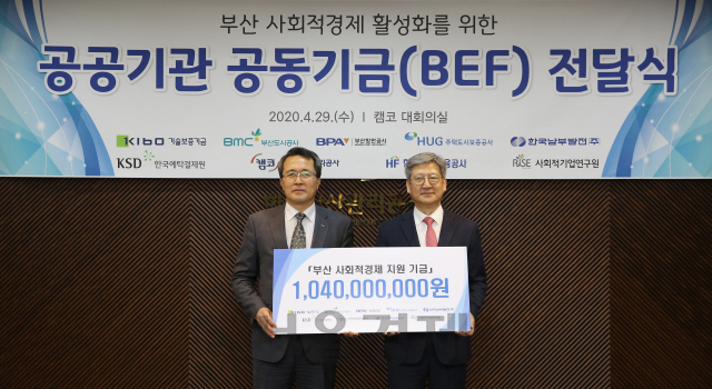 문성유(왼쪽) 한국자산관리공사장은 29일 부산국제금융센터(BIFC)에서 부산 지역 8개 공공기관이 공동 조성한 부산 사회적경제 지원기금(BEF)을 조영복 사회적기업연구원장에게 전달하고 있다. /사진제공=한국자산관리공사