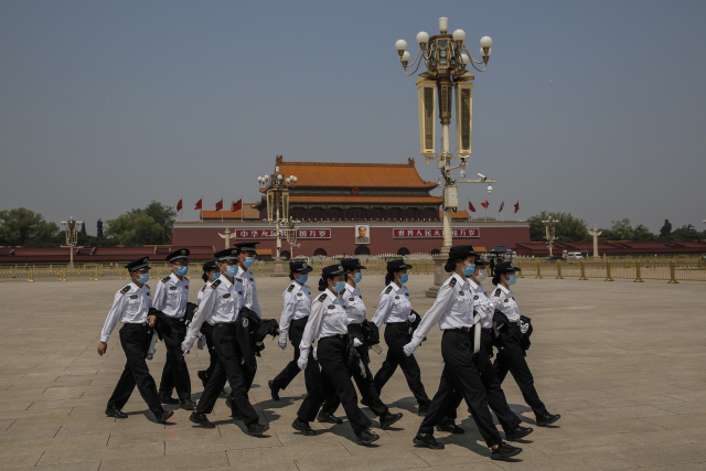 28일 중국 베이징 톈안먼광장에서 공안경찰이 마스크를 쓴 채 줄지어 이동하고 있다./베이징=EPA연합뉴스