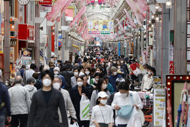 지난 19일 일본 도쿄에서 마스크를 쓴 사람들이 쇼핑가를 지나가고 있다. /도쿄=로이터연합뉴스