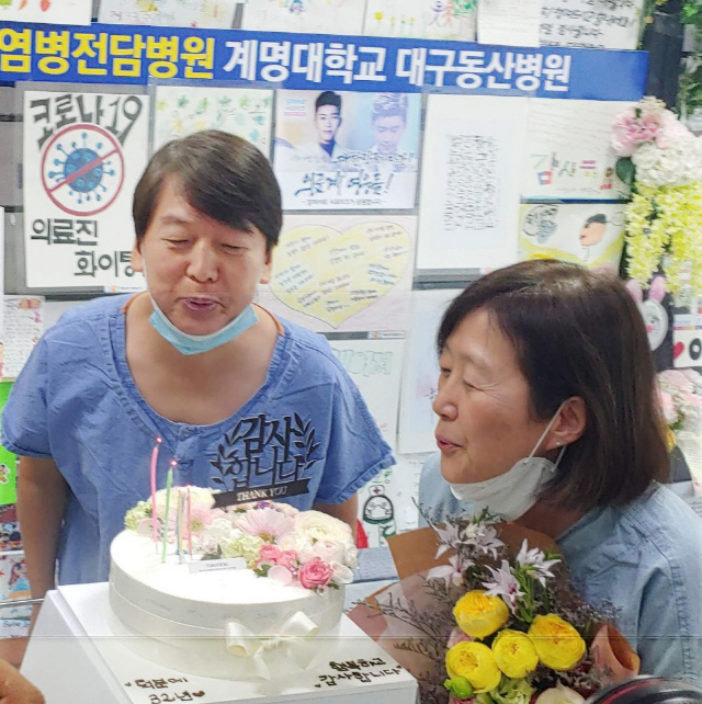 안철수 국민의당 대표와 부인 김미경 서울대 교수가 30일 대구시 중구 계명대학교 대구동산병원에서 의료진으로부터 결혼기념일을 축하하는 꽃다발과 케이크를 선물 받고 있다. 안 대표 부부는 신종 코로나바이러스 감염증(코로나19) 지역거점병원인 대구동산병원에서 현재 의료봉사를 하고 있다./국민의당 제공=연합뉴스