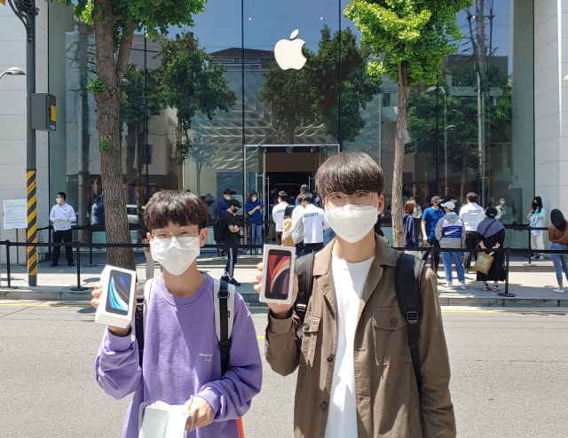서울 강남 신사동 애플 가로수길 매장에서 가장 먼저 아이폰SE를 구매한 최준서(오른쪽), 한승민군이 제품을 들어올려보이고 있다./김성태 기자