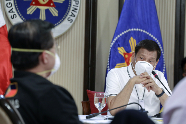 로드리고 두테르테(오른쪽) 필리핀 대통령이 지난달 23일(현지시간) 마닐라 말라카낭궁에서 마스크를 쓴 채 신종 코로나바이러스 감염증(코로나19) 대응 범정부 태스크포스 회의를 주재하고 있다. /마닐라=AP연합뉴스