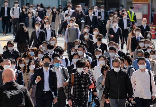 7일 일본 도쿄의 한 철도역 인근에서 시민들이 마스크를 쓴 채 길을 건너고 있다. /도쿄=AFP연합뉴스
