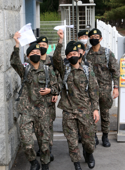 코로나19 확산 방지를 위해 통제됐던 장병 휴가가 정상 시행된 8일 오전 강원 춘천시 육군 2군단 사령부 위병소에서 병사들이 휴가증을 들고 밝은 표정으로 위병소를 나서고 있다.   /춘천=연합뉴스