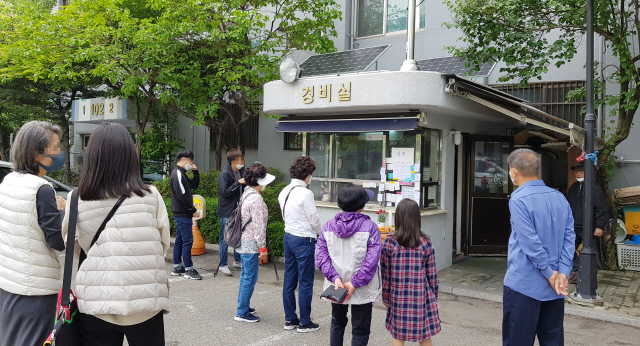 11일 오전 서울 강북구 우이동의 한 아파트에서 전날 극단적 선택을 한 아파트 경비원을 추모하기 위해 주민들이 고인이 생전 생전에 근무하던 경비 초소에 마련된 분향소에 모여있다. /연합뉴스