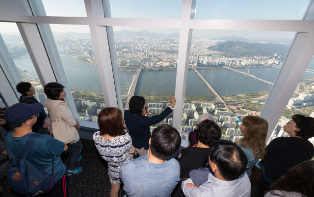 롯데월드타워 전망대 서울스카이 123층 전망대에서 관람객들이 직원의 설명을 듣고 있다.