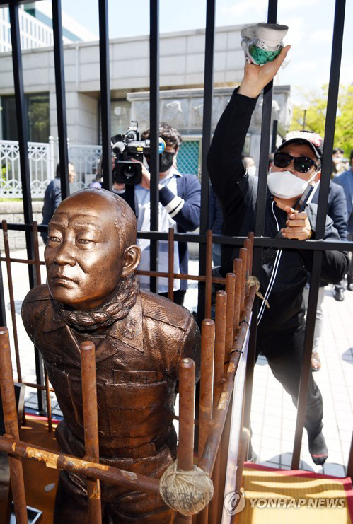 전두환 전 대통령의 사자 명예훼손 혐의 재판이 열린 4월27일 광주지방법원 정문 앞에서 5·18 유족들이 이른바 ‘전두환 치욕 동상’을 가격하고 있다. /연합뉴스