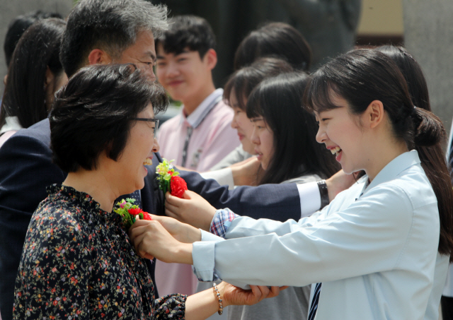 지난 2018년 5월 15일 충남 논산 강경고등학교 학생 대표들이 스승의날 기념탑 앞에서 선생님에게 꽃을 달아드리고 있다. /논산=연합뉴스