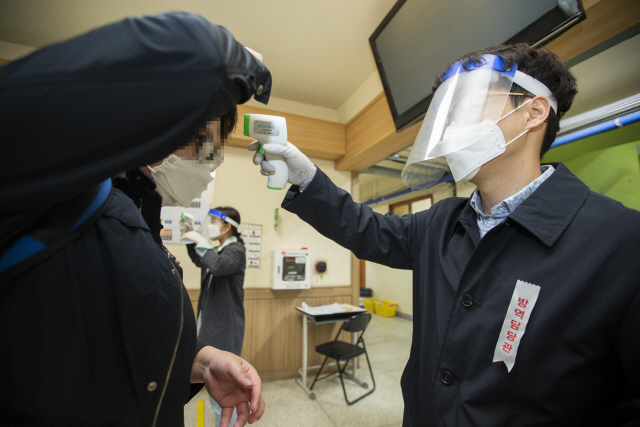 지난 2월29일 시행 예정이다 신종 코로나바이러스감염증(코로나19) 확산 여파로 지난 16일 뒤늦게 진행된 국가공무원 5급 공채 시험이 열린 서울 시내 한 고사장에서 응시생들이 발열 검사를 받고 있다./사진제공=인사혁신처