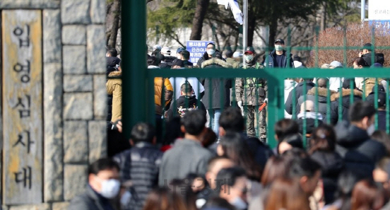 지난 2월 3일 오후 충남 논산 육군훈련소 입영심사대 앞에서 입영장병과 가족 및 친구들이 인사하고 있다. 훈련소 측은 신종 코로나19 확산 방지 차원에서 이날 예정된 입영행사를 취소했다.   /논산=연합뉴스