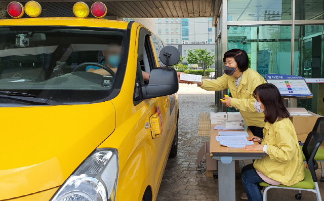 고3 학생들의 등교수업을 앞두고 학원 발 신종 코로나 바이러스 감염증(코로나19) 확산 우려가 높아지는 가운데 노옥희(뒤쪽) 울산시교육감이 지난 16일 울산과학관에서 학원, 교습소, 개인과외교습자 등 지역 학원 관계자에게 ‘드라이브 스루’ 방식으로 비접촉체온계를 나눠주고 있다.  /울산=연합뉴스