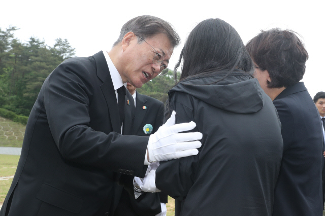 문재인 대통령이 제40주년 5·18민주화운동 기념일인 18일 광주 북구 5·18민주묘지 제2묘역에서 고(故) 이연씨 묘를 참배한 뒤 유족을 위로하고 있다.  고인은 전남대 1학년에 재학 중이던 1980년 5월27일 YMCA 회관에서 계엄군과 총격전 중 체포돼 전신 구타를 당했다./연합뉴스