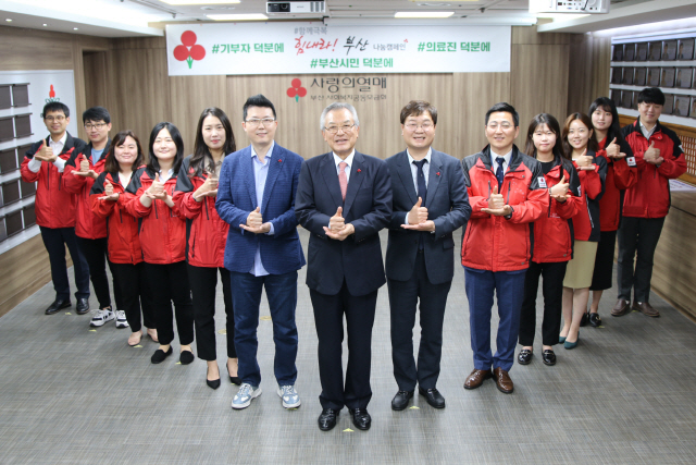 신정택(가운데) 부산사랑의열매 회장과 송연익(오른쪽) 에스엠산업 대표, 손희동(왼쪽) 뉴라인성형외과 대표원장이 사랑의열매 직원과 함께 ‘덕분에 챌린지’에 참여하고 있다./사진제공=부산사랑의열매