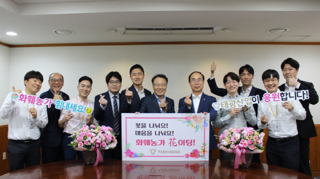 홍현민(오른쪽 여섯번째) 태광산업 대표가 18일 서울 본사에서 임직원들과 화훼농과 돕기 릴레이 캠페인에 참여한 뒤 기념촬영을 하고 있다. /사진제공=태광산업