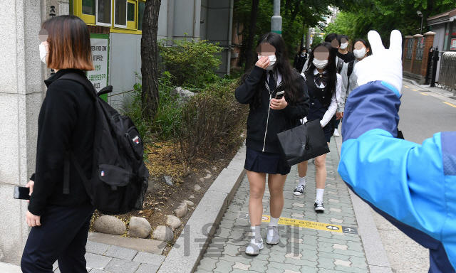 코로나19 확산으로 미뤄졌던 고등학교 3학년의 등교 수업이 시작된 20일 오전 서울의 한 고등학교에서 교사가 삼삼오오 함께 등교하는 학생들에게 상호 간 거리 유지를 지도하고 있다./오승현기자 2020.05.20