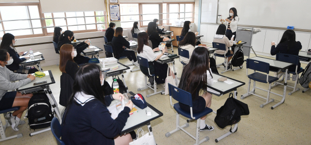 80일 만에 등교 수업이 시작된 20일 오전 서울 한 고등학교에서 3학년 학생들이 교실에서 생활 방역 수칙에 대한 설명을 듣고 있다. /연합뉴스