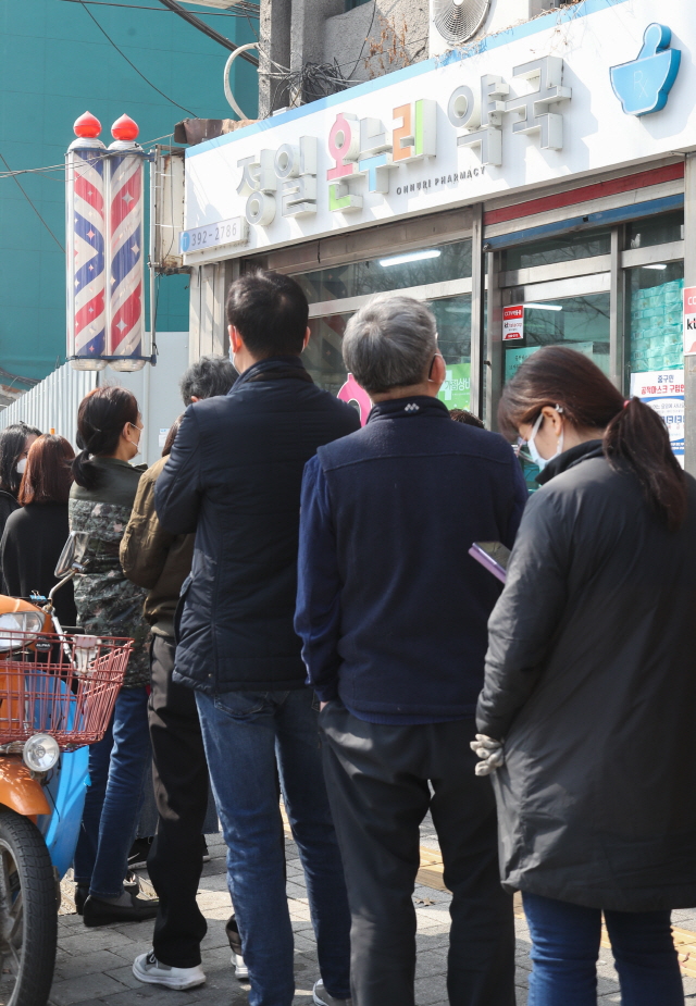 지난달 19일 서울 시내에 한 약국에서 시민들이 공적마스크 구매하기 위해 줄을 서 있다./연합뉴스