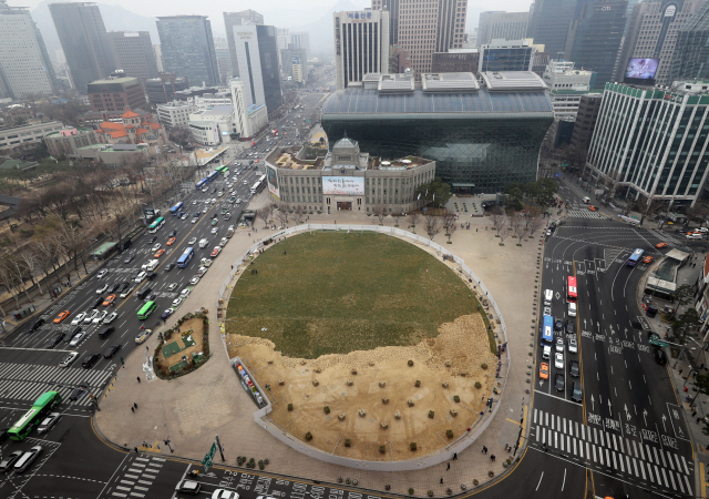 서울 시청 앞 광장에서 작업자들이 서울광장의 잔디를 다시 깔고 있다. /연합뉴스