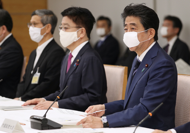 아베 신조(오른쪽) 일본 총리가 지난 21일 총리 사무실에서 열린 코로나19 대응 태스크포스 회의에서 발언하고 있다. /도쿄=AFP연합뉴스