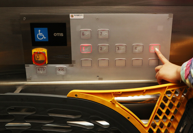 이마트를 찾은 고객이 ‘항균 필름’이 부착된 승강기 버튼을 누르고 있다./사진제공=이마트