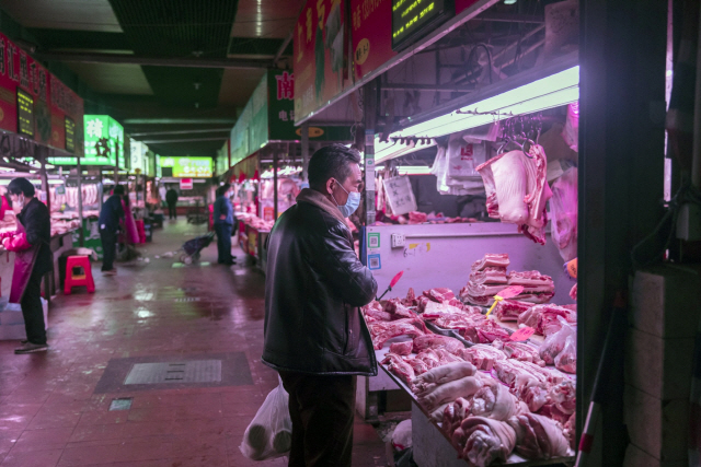 지난 3월 13일(현지시간) 중국 상하이의 한 슈퍼마켓에서 마스크를 착용한 시민이 돼지고기 매장에서 판매 중인 고기를 살펴보고 있다. /상하이=블룸버그