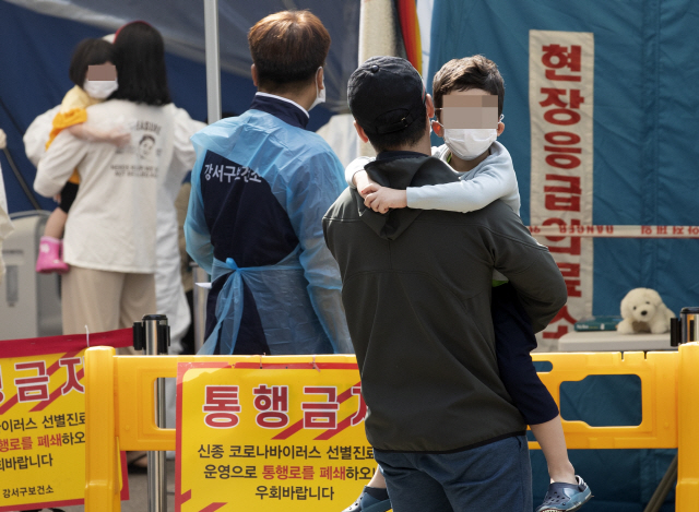 26일 오전 부모님과 함께 서울 강서구 보건소 선별진료소를 찾은 어린이들이 신종 코로나바이러스 감염증(코로나19) 검사를 받은 후 진료소를 나서고 있다. /연합뉴스