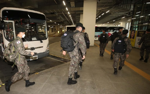 휴가 나온 육군 장병들이 버스에서 내려 각자의 행선지로 향하고 있다.   /연합뉴스