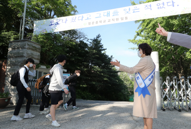 27일 오전 서울 종로구 청운중학교에서 선생님들이 등교하는 학생들을 향해 간격을 유지하도록 지도하고 있다. /연합뉴스