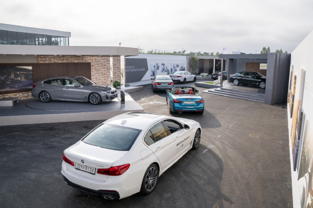 BMW가 27일 영종도 드라이빙센터에서 개최한 뉴 5 시리즈와 뉴 6 시리즈 그란 투리스모 세계 최초 공개행사 참석자들이 드라이브 스루 방식으로 새로운 모델을 살펴보고 있다. /연합뉴스