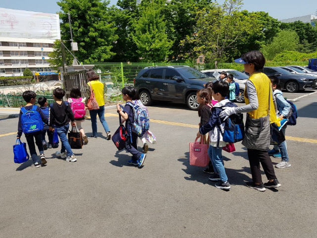 교통안전지도사가 초등학생들의 하굣길에 동행하며 안전하게 귀가시키고 있다./사진제공=강동구