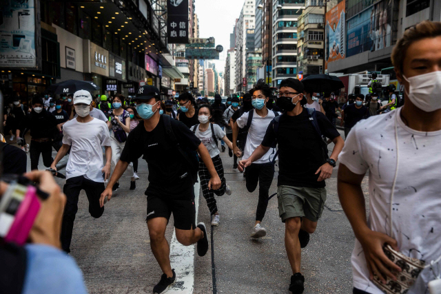 27일(현지시간) 홍콩의 몽콕 지구에 모인 민주화 시위대가 경찰이 해산을 시도하자 달아나고 있다. /AFP연합뉴스
