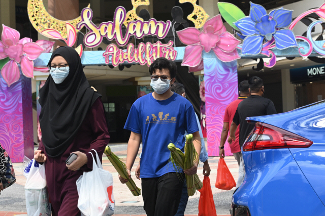 지난 21일 싱가포르에서 마스크를 착용한 사람들이 길을 걷고 있다. /AFP연합뉴스
