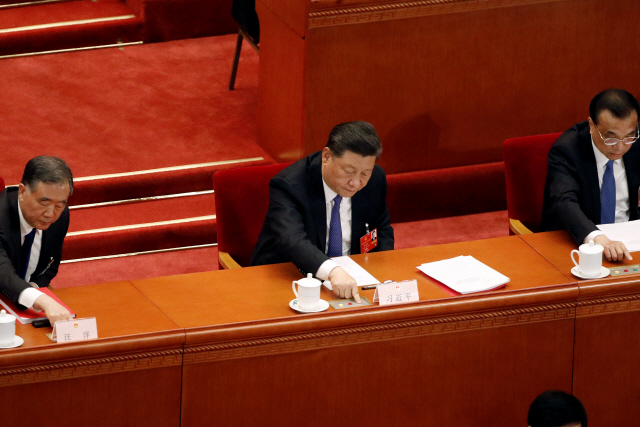 28일 중국 전국인민대표대회가 열리는 베이징 인민대회당에서 시진핑(가운데) 중국 국가주석이 표결을 진행하고 있다. 이날 전인대는 홍콩 내 반(反)중국 행위를 처벌하는 홍콩 국가보안법 초안을 찬성 2,878명, 반대 1명, 기권 6명의 압도적 찬성으로 통과시켰다.    /로이터연합뉴스