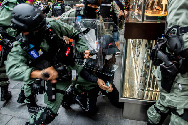 27일 홍콩 센트럴지구에서 진압경찰이 시위에 참여한 한 여성을 가격하고 있다. 이날 중국이 시위활동에 단순 참여한 사람도 처벌하는 내용의 한층 강화된 홍콩 보안법 수정안을 공개하면서 이에 반발하는 시민들이 시내 곳곳에서 시위에 나섰다./AFP연합뉴스
