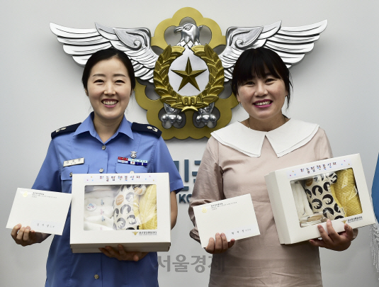 공군의 김지영(왼쪽) 소령과 황세정 주무관이 출산선물 ‘하늘맘 행복 상자’를 받은 뒤 함박 웃음을 짓고 있다.   /사진제공=공군