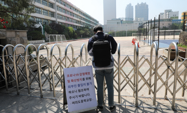 등교를 중지한 서울 여의도중학교 관계자가 29일 학교 정문으로 들어가고 있다. /연합뉴스