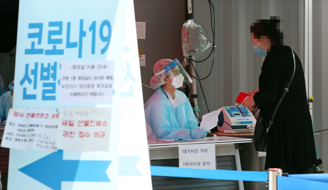 1일 오전 서울 영등포구 보건소에 마련된 코로나19 선별진료소에서 의료진이 시민들의 진료 접수를 돕고 있다. /연합뉴스