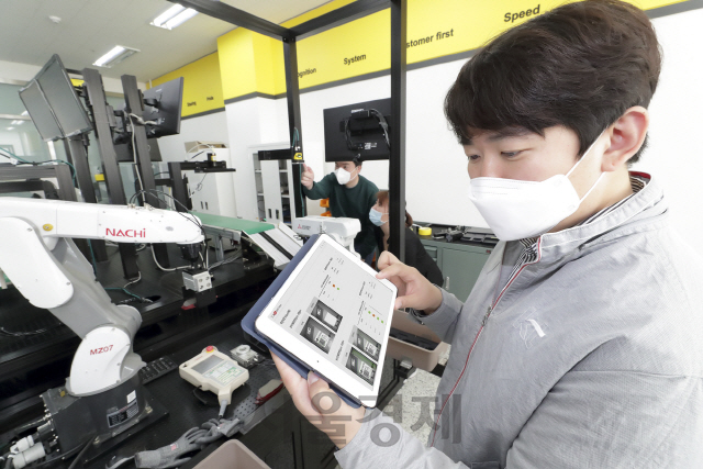 KT와 코그넥스 직원들이 경기도 수원 코그넥스코리아 연구소에서 ‘KT 5G 스마트팩토리 머신비전’ 솔루션을 점검하고 있다./사진제공=KT