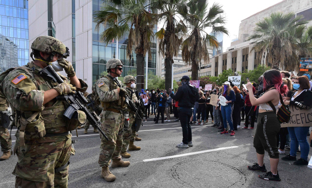 1일(현지시간) 미국 캘리포니아주 로스앤젤레스(LA)에서 조지 플로이드 사망과 관련해 인종차별에 항의하는 시위대가 주 방위군과 대치하고 있다. 이날 LA 한인타운에는 항의 시위가 시작된 후 처음으로 캘리포니아 주 방위군 병력 30여명이 전격 투입돼 경계에 나섰다./AFP연합뉴스