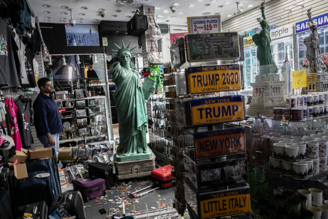 2일(현지시간) 뉴욕 타임스퀘어에서 한 상점 주인이 약탈당한 가게 내부 모습을 허탈한 표정으로 바라보고 있다./AFP연합뉴스