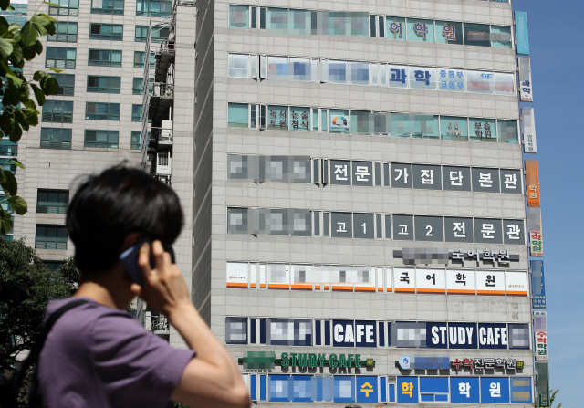 지난 1일 오후 서울 목동 학원가에서 한 학생이 전화통화를 하며 지나가고 있다. /연합뉴스