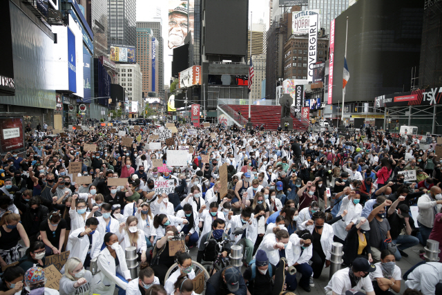 타임스스퀘어 달군 추모 열기  미국 뉴욕 맨해튼 타임스스퀘어 거리에 2일(현지시간) 코로나19 대응 의료진과 이들을 응원하는 시민들, 흑인 사망사건에 항의하는 시위대가 한데 모여 경찰의 과잉진압으로 사망한 조지 플로이드를 추모하고 있다.   /UPI연합뉴스