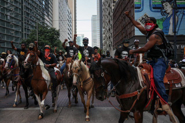 2일(현지시간) 미국 텍사스주 휴스턴에서 시위대가 말을 타고 미국 백인 경찰의 가혹행위로 흑인 남성 조지 플로이드가 사망한 사건에 항의하는 시위를 벌이고 있다./로이터연합뉴스