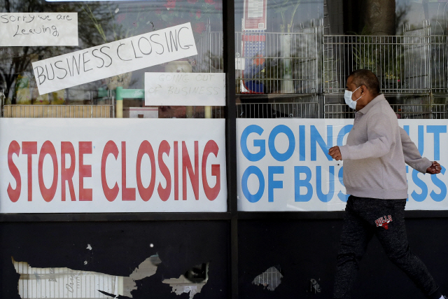 행인이 코로나바이러스 사태로 문을 닫은 상점 앞을 지나고 있다. /AP연합뉴스