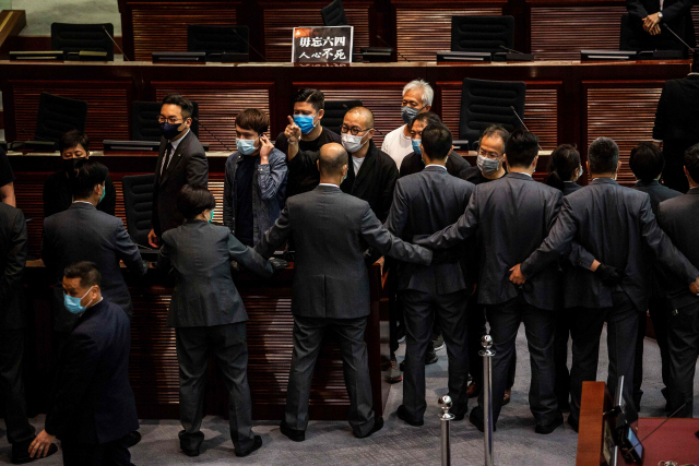 친중파가 장악한 홍콩 입법회가 4일 ‘국가법’을 강행하는 것에 대해 민주파 의원들이 반대하는 것을 경위들이 동원돼 가로막고 있다. /AFP연합뉴스