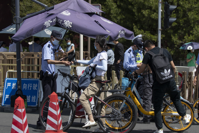 중국이 경찰력을 동원해 4일 톈안먼광장 주변을 통제한 가운데 자전거를 타고 지나가는 시민들도 신분증 및 가방 검사를 받고 있다. /AP연합뉴스