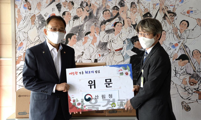 박종호(사진 왼쪽) 산림청장이 대전보훈요양원 김주천(〃오른쪽) 원장에게 위로 물품을 전달하고 있다. 사진제공=산림청